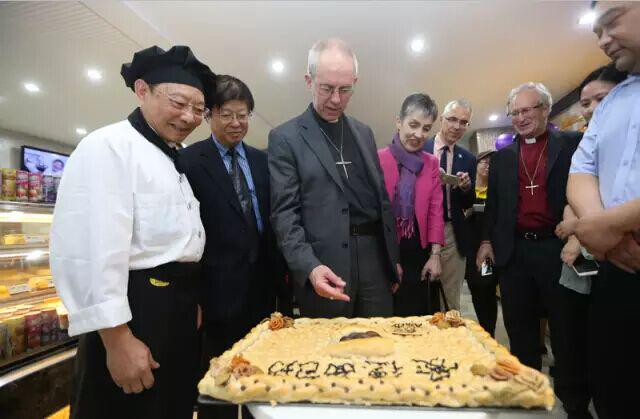 邝振中大师（左一）向大主教等介绍“五饼二鱼”面包。（图：爱德基金会）